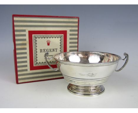 A George VI silver two-handled porringer, of stepped hemispherical form and raised over a conforming foot, with volute bracke