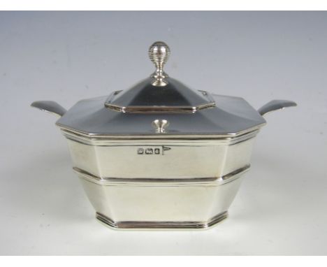A George V silver sugar box, of tapering square section with canted corners and banded decoration, having a subtly domed hing