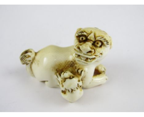 A late Edo / early Meiji Japanese carved ivory netsuke of a Shi Shi and pup, character marks to base, 4.5 x 3.5 cm high 