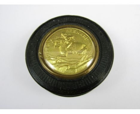 An early 19th Century Napoleonic Bois Durcie snuff box, of circular section, the slip cover inset with a gilt medallion depic
