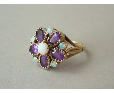 An opal and amethyst cocktail ring, in a flower head arrangement with central crown set opal cabochon, above five claw and co