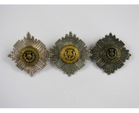 A Scots Guards officer's silver and enamel cap badge, another in white metal and an electroplate example 