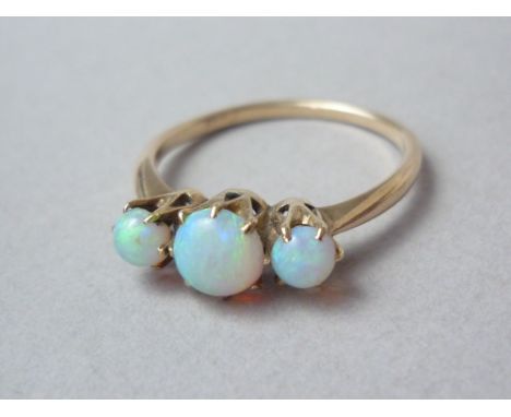 A three stone opal dress ring, the central cabochon stone of approximately .50ct flanked by a pair of 0.9ct stones, crown set