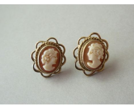 A handed pair of shell cameo stud earrings, carved with the profile portrait of a young lady, bezel set within a 9ct gold rop