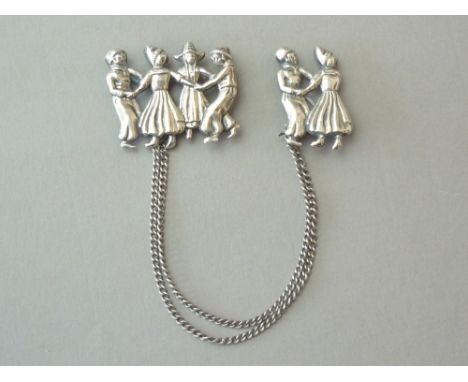 A Lang Jewellery Company silver cloak clasp, composed of two brooches, each modelled as Dutch dancers, connected by two rows 