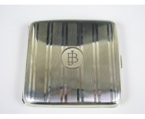 A George V silver cigarette case, of contoured cushion form, having engine turned banded decoration and a central circular ca
