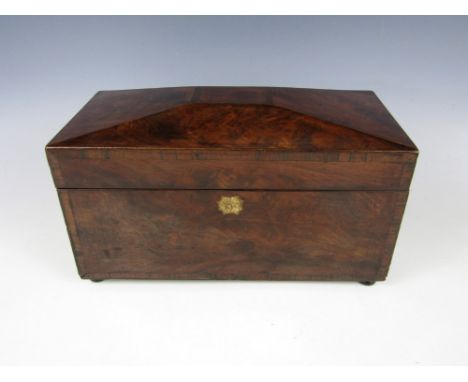 A Georgian mahogany tea caddy, with a shallow, truncated pyramidal lid, cross banded decoration and bun feet, opening to reve