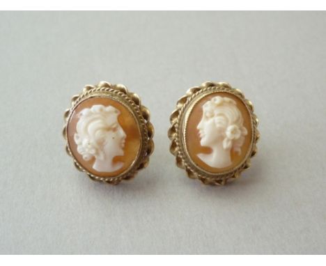 A pair of shell cameo stud earrings, both carved with the profile portrait of a young lady, collet set within a rope and spir