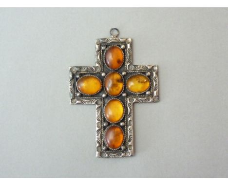 A sterling silver and amber cruciform pendant, comprising six cabochon stones, millegrain and pellet set over a slender cross