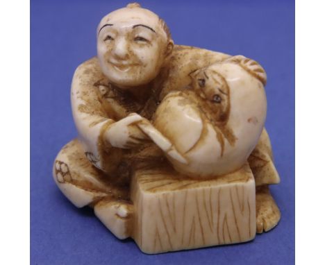 Ivory carved netsuke in the form of a seated man holding a baby, H: 32 mm, signed to base. P&amp;P Group 1 (£14+VAT for the f
