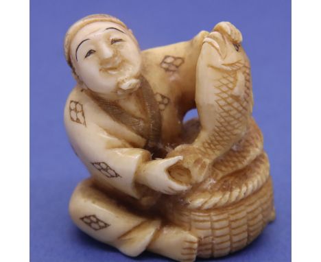 Ivory carved netsuke in the form of a street fish vendor with a basket and two fish, H: 36 mm, signed to base. P&amp;P Group 
