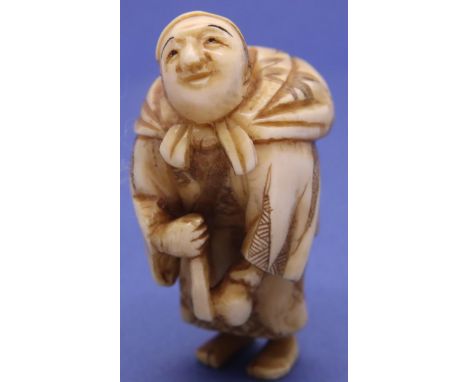 Ivory carved netsuke in the form of a man carrying a sack, looking up, H: 45 mm, signed to base. P&amp;P Group 1 (£14+VAT for