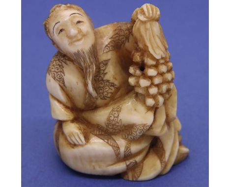 Ivory carved netsuke in the form of a bearded man holding fruit, H: 39 mm, signed to base. P&amp;P Group 1 (£14+VAT for the f