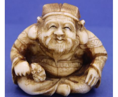 Ivory carved netsuke in the form of a seated God holding a hammer, H: 40 mm, unsiged. P&amp;P Group 1 (£14+VAT for the first 