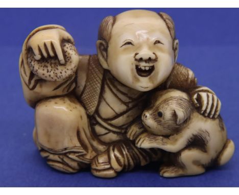 Ivory carved netsuke in the form of a seated smiling man holding a sponge with a monkey, H: 32 mm, unsigned. P&amp;P Group 1 