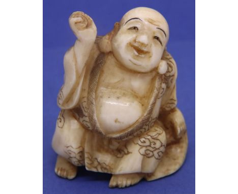 Ivory carved netsuke in the form of a seated figure holding a hammer, H: 42 mm, signed to base. P&amp;P Group 1 (£14+VAT for 