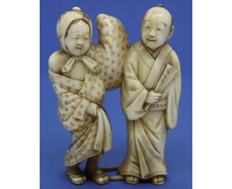 Ivory carved netsuke in the form of a standing man and woman, H: 60 mm, signed to back of man. Overall good condition. P&amp;