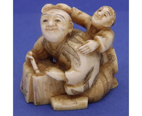 Ivory carved netsuke in the form of a scribe with a boy on his back carrying a paintbrush, H: 35 mm, signed to base. P&amp;P 