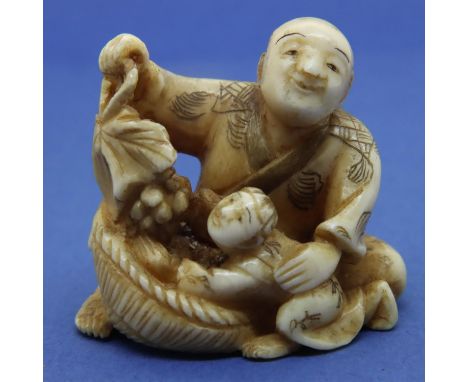 Ivory carved netsuke in the form of a seated man with a child holding a fruit group, H: 34 mm, signed panel to base. P&amp;P 