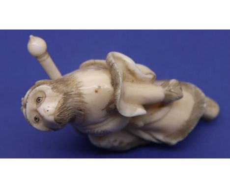 Ivory carved netsuke in the form of an anthropomorphic monkey as a warrior, lacking one leg, H: 71 mm, unsigned. P&amp;P Grou