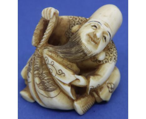 Ivory carved netsuke in the form of a seated God holding a bag, H: 36 mm, signed to base. P&amp;P Group 1 (£14+VAT for the fi
