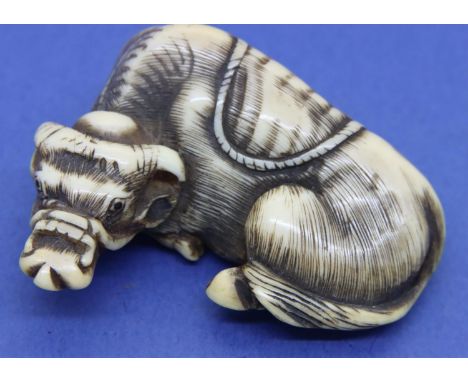 Ivory carved netsuke in the form of a reclining water buffalo, H: 48 mm, signed to base. P&amp;P Group 1 (£14+VAT for the fir