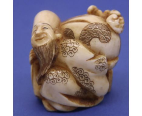 Ivory carved netsuke in the form of a God carrying a sack, H: 38 mm, signed to base. P&amp;P Group 1 (£14+VAT for the first l