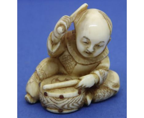 Ivory carved netsuke in the form of a drummer with stone studded drum, H: 33 mm, signed in panel to base. P&amp;P Group 1 (£1