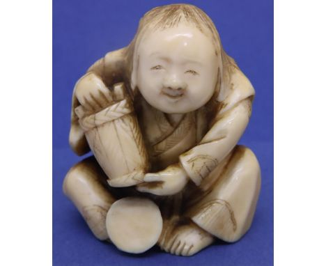 Ivory carved netsuke in the form of a seated man with a bucket, H: 45 mm, signed to base. P&amp;P Group 1 (£14+VAT for the fi