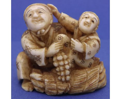 Ivory carved netsuke in the form of a seated man and boy with fruit, H: 38 mm, signed to base. P&amp;P Group 1 (£14+VAT for t