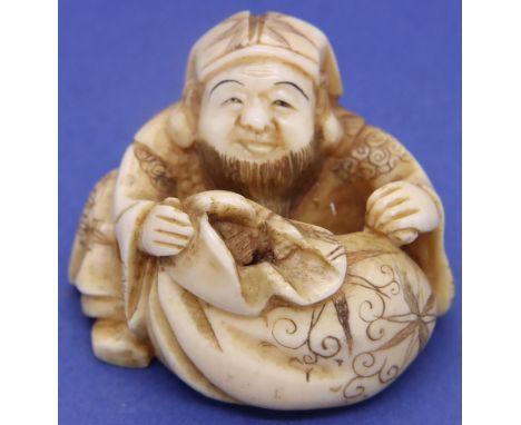 Ivory carved netsuke in the form of a seated bearded man with a sack, H: 35 mm, signed to base. P&amp;P Group 1 (£14+VAT for 