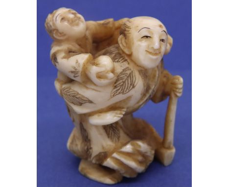 Ivory carved netsuke in the form of a man carrying an axe with a boy on his back, H: 42 mm, signed to base. P&amp;P Group 1 (