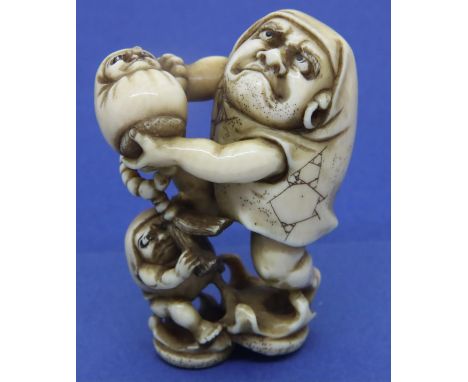 Ivory carved netsuke in the form of a Daruma  group, H: 52 mm, signed on panel to base. P&amp;P Group 1 (£14+VAT for the firs