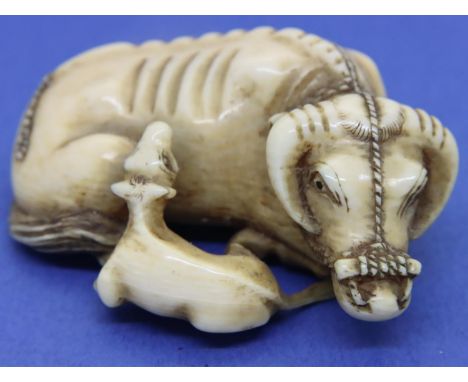 Ivory carved netsuke in the form of a recumbent water buffalo and calf with rope tether, L: 55 mm, unsigned. P&amp;P Group 1 