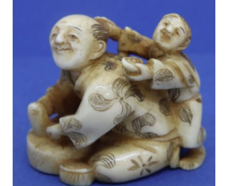 Ivory carved netsuke in the form of a mason with a boy on his back, H: 34 mm, signed to base. P&amp;P Group 1 (£14+VAT for th
