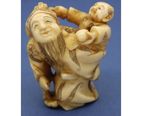 Ivory carved netsuke in the form of a bearded man with a boy carrying a ball and an octopus on his back, H: 48 mm, signed to 