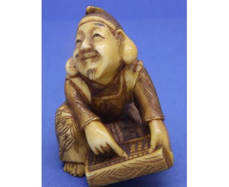 Ivory carved netsuke in the form of a seated man using an abacus, H: 45 mm, signed to base. P&amp;P Group 1 (£14+VAT for the 