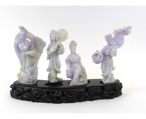 A set of four Chinese pale purple/pale green jade carvings modelled as figures at leisure on a carved hardwood stand, overall