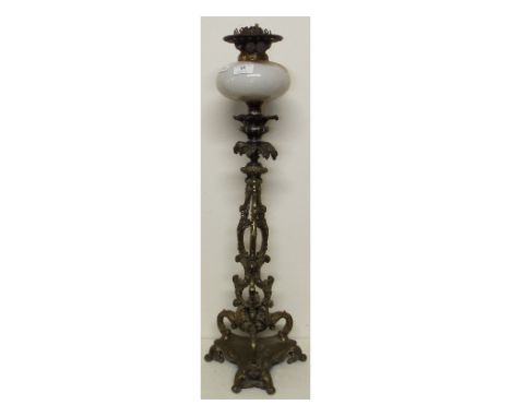 A brass oil lamp, with white glass reservoir, 70 cm high
