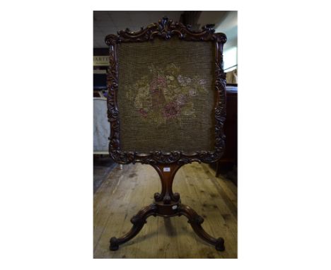 An early Victorian rosewood firescreen, inset a needlework panel, on a tripod base, 68 cm wide