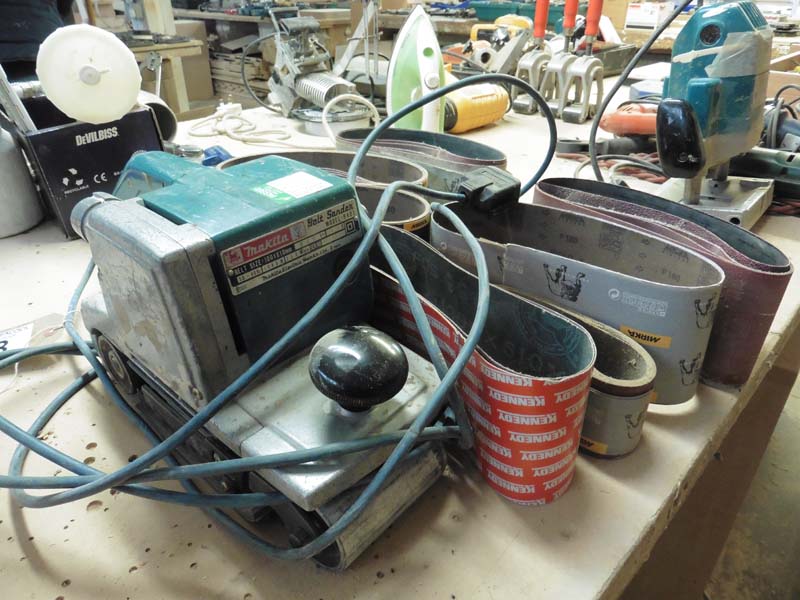 Makita model 9401 belt sander and a quantity of sanding belts