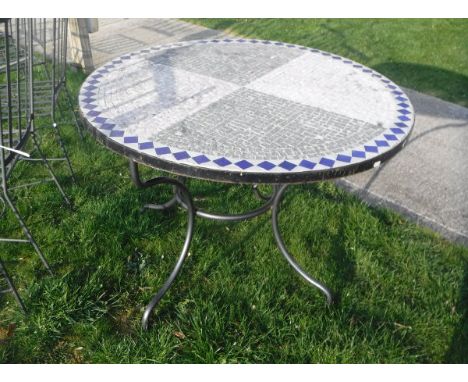 A tile top circular garden table and a set of eight wrought iron chairs with slatted backs and seats (6 plus 2)