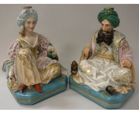 A pair of 19th Century Jacob Petit porcelain dressing table scent bottles as seated Turks, he with a hookah pipe, she with a 