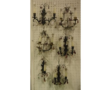 Two pairs of early 20th Century twin light wall sconces with amethyst and clear class drops together with a further single tw