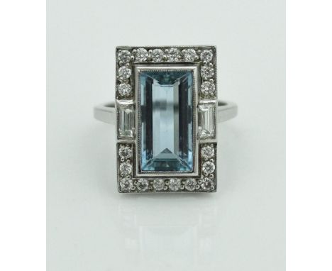An 18 carat white gold aquamarine and diamond ring in the Art Deco manner, the aquamarine in baguette form measures approxima