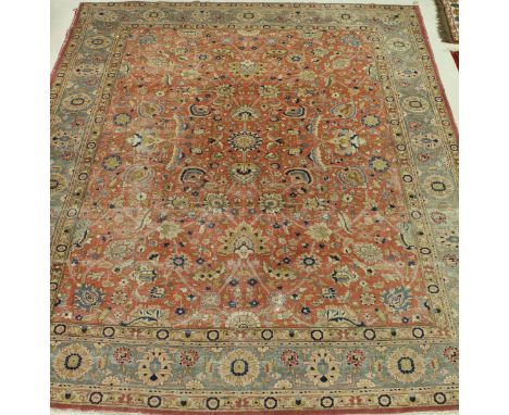 A Ziegler style carpet the central panel set with all over floral decoration on a red ground within a stepped pink and turquo