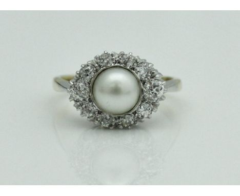 A ladies dress ring, the central pearl within an oval tapered border of old cut diamonds in 18 carat gold setting, size M