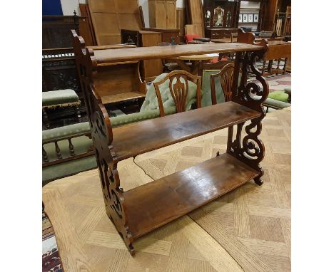 A circa 1900 mahogany three tier waterfall shelf unit on fretwork carved supports