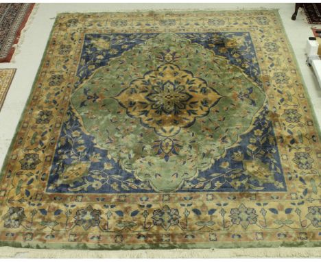 A Persian style carpet the central panel set with floral decorated medallion on a green and blue floral decorated ground with