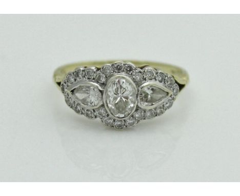 An 18 carat gold diamond-set ring, the central oval diamond flanked by two pear-shaped diamonds totalling approximately 1.1 c